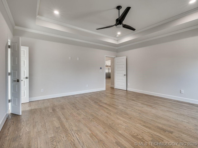 unfurnished room featuring ornamental molding, a raised ceiling, and light wood-type flooring