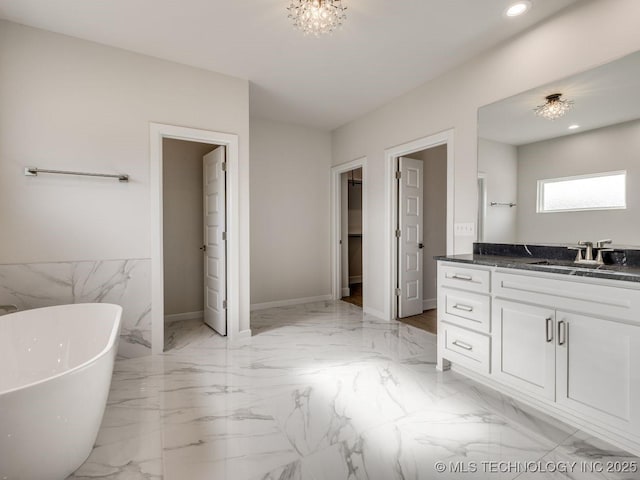 bathroom featuring a washtub and vanity