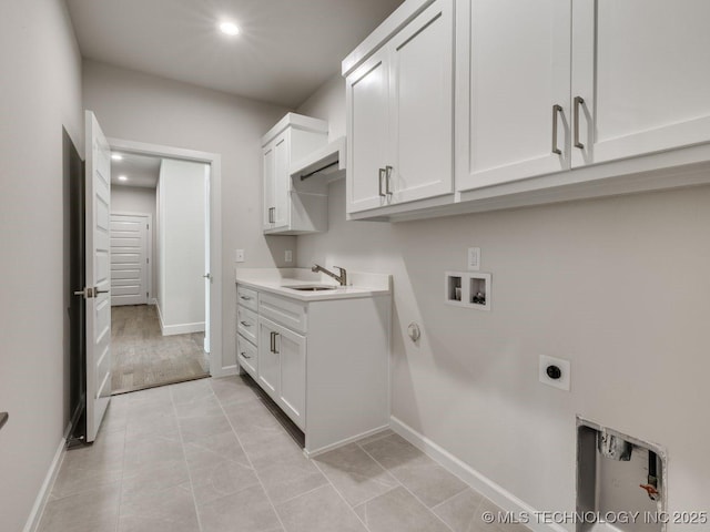 laundry area featuring sink, cabinets, light tile patterned floors, washer hookup, and hookup for an electric dryer