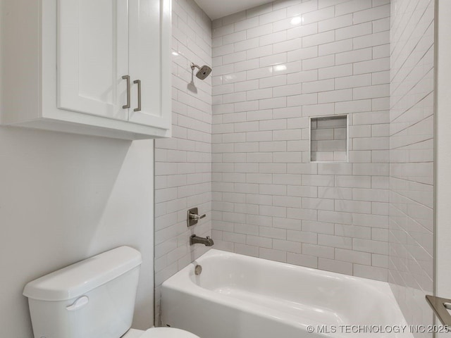 bathroom with tiled shower / bath combo and toilet