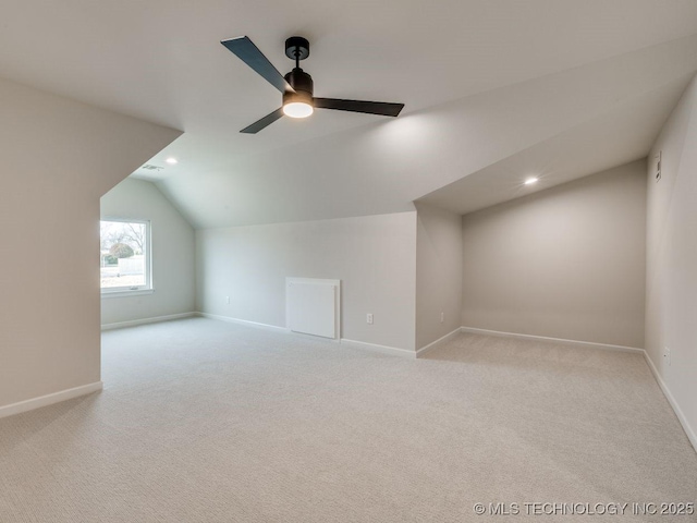 additional living space featuring lofted ceiling, light carpet, and ceiling fan