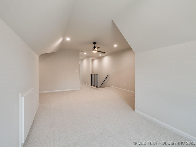 additional living space featuring vaulted ceiling, light carpet, and ceiling fan