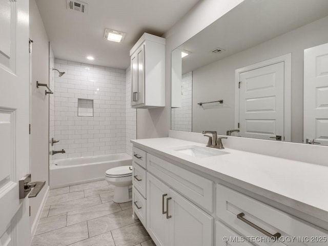 full bathroom featuring vanity, tiled shower / bath combo, tile patterned floors, and toilet