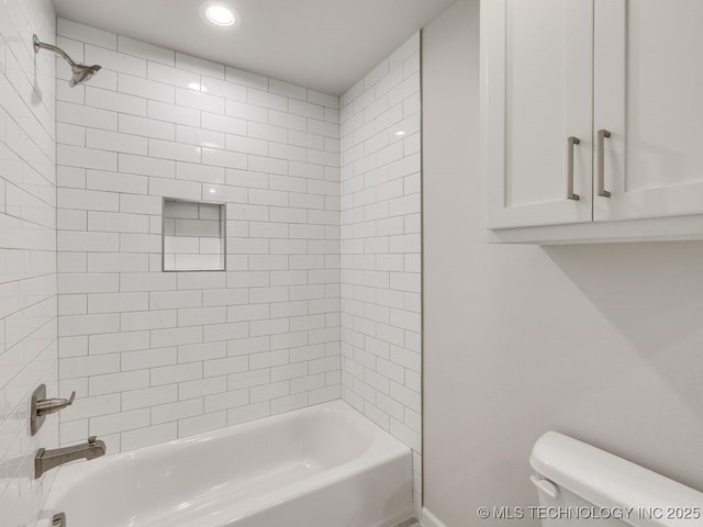 bathroom with tiled shower / bath combo and toilet