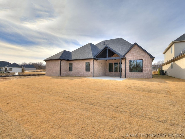 back of house featuring central AC unit, a yard, and a patio area