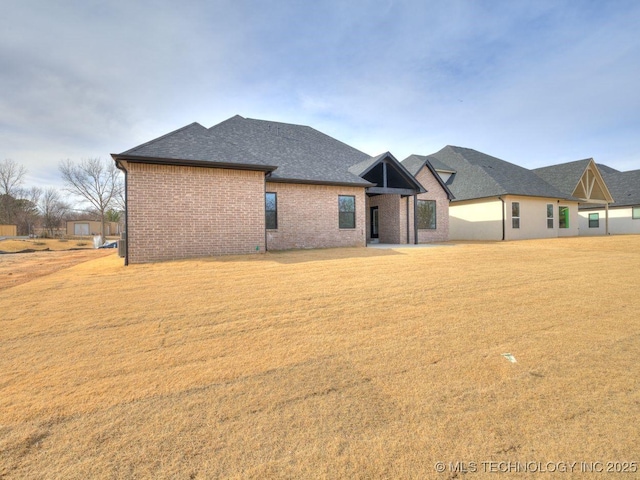 rear view of house featuring a yard