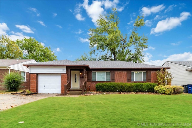 ranch-style house featuring a garage and a front lawn