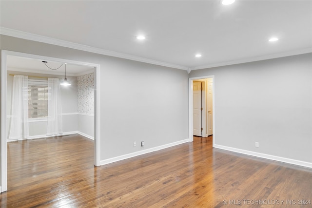 empty room with dark hardwood / wood-style floors and crown molding