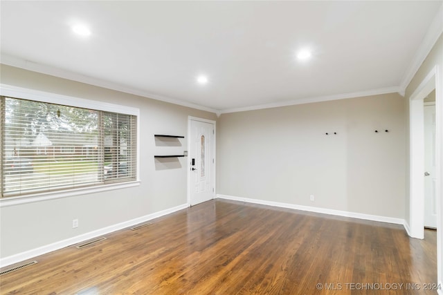 spare room featuring dark hardwood / wood-style flooring and crown molding