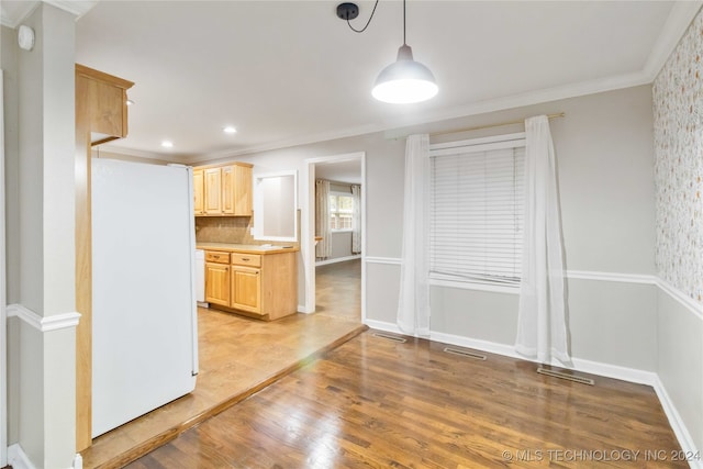 kitchen featuring light hardwood / wood-style floors, white refrigerator, ornamental molding, light brown cabinets, and decorative light fixtures