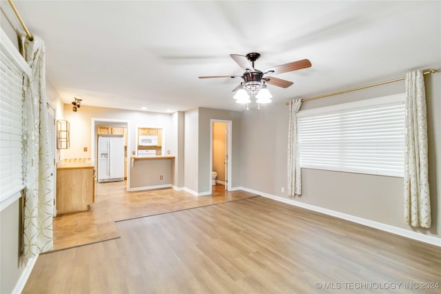 unfurnished living room featuring a brick fireplace, light hardwood / wood-style flooring, and ceiling fan