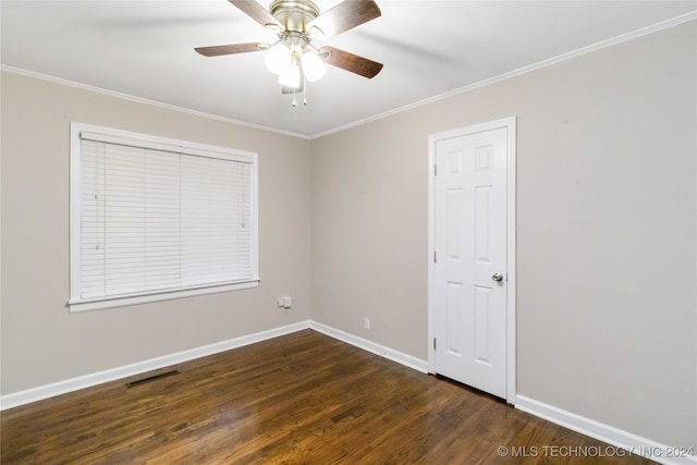 empty room featuring dark wood-type flooring, ceiling fan, and crown molding