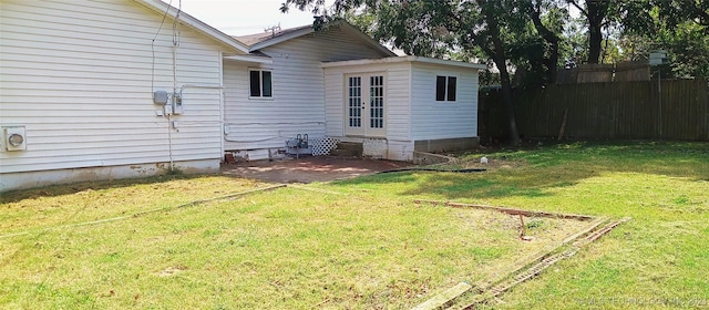 rear view of property featuring a lawn and a patio