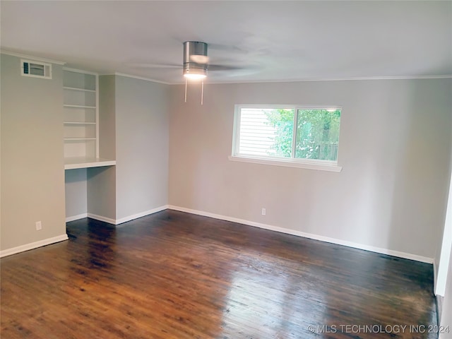 empty room featuring crown molding, dark wood-type flooring, and ceiling fan