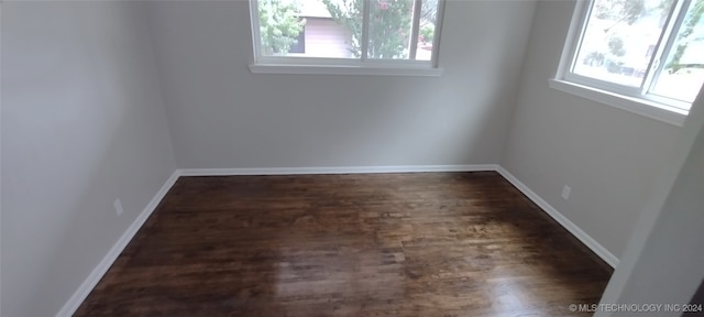 unfurnished room with a wealth of natural light and dark hardwood / wood-style flooring