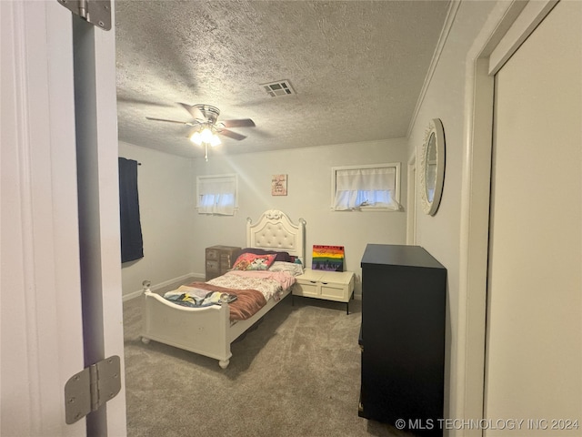 carpeted bedroom featuring a textured ceiling and ceiling fan