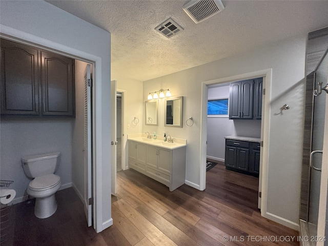 bathroom featuring a textured ceiling, vanity, toilet, and hardwood / wood-style flooring