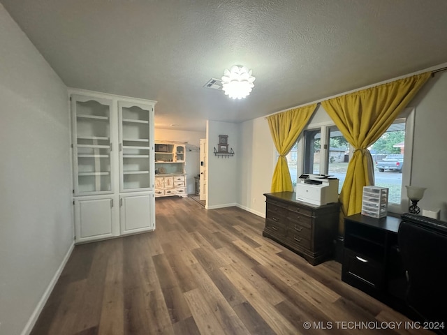 misc room featuring a textured ceiling and dark wood-type flooring