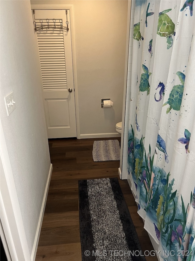 bathroom with walk in shower, hardwood / wood-style floors, and toilet