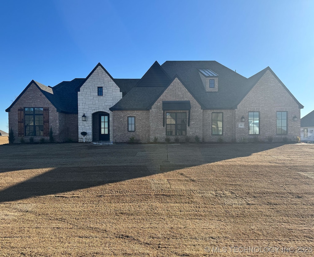 french provincial home with a front yard