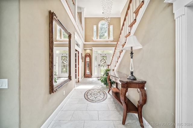 entrance foyer featuring ornamental molding, an inviting chandelier, and a high ceiling