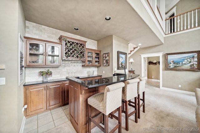 kitchen featuring a kitchen breakfast bar, a center island, light colored carpet, and tasteful backsplash