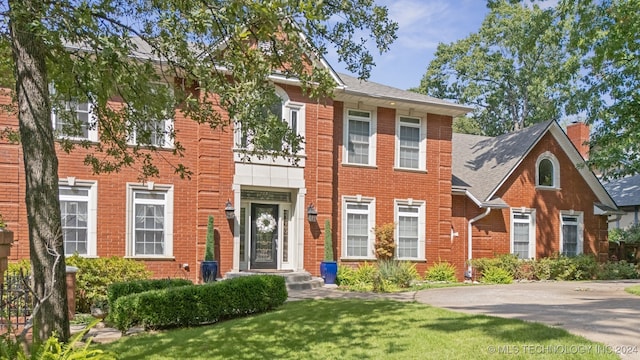 colonial home featuring a front lawn