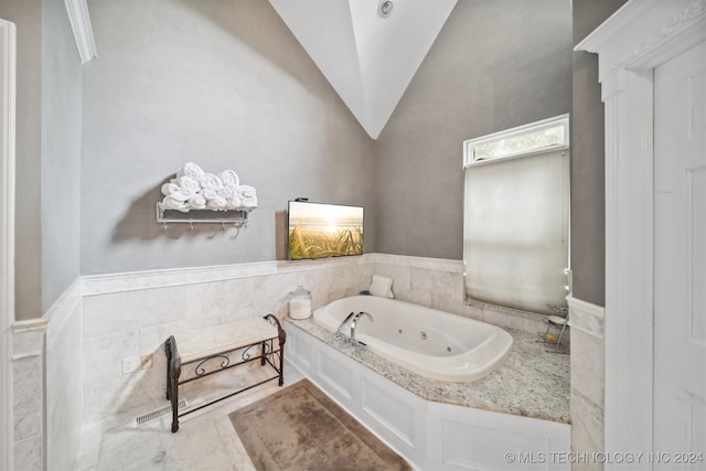 bathroom featuring lofted ceiling and a tub