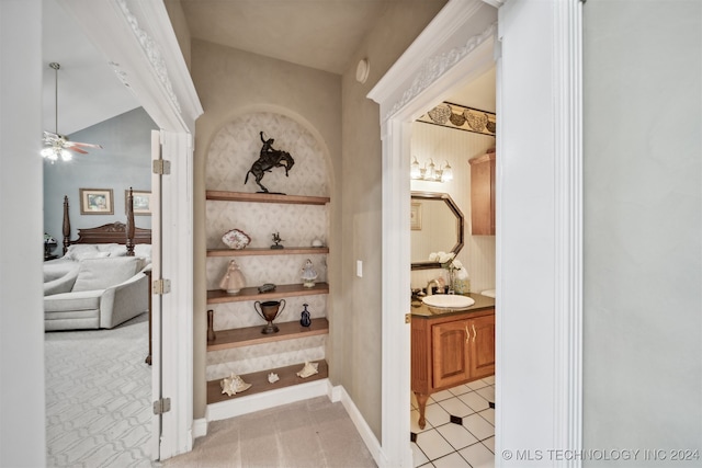 corridor featuring sink and light colored carpet