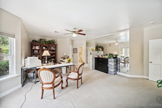 dining room featuring ceiling fan and light colored carpet