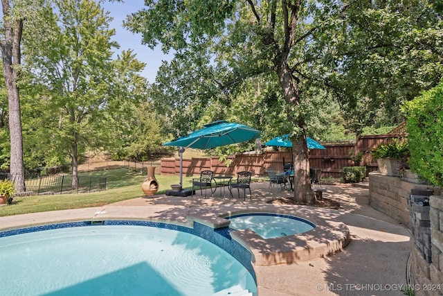 view of pool featuring a yard, a patio area, and an in ground hot tub