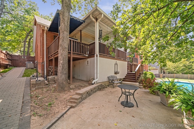 rear view of property featuring a patio area and a pool side deck