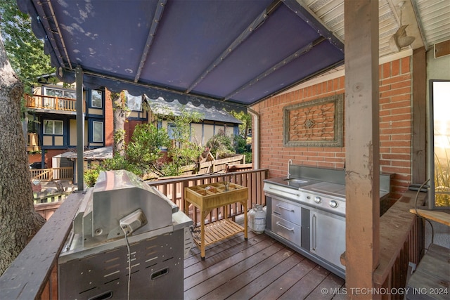 deck with an outdoor kitchen and a grill