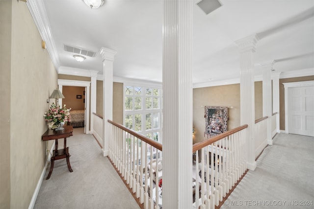 hallway featuring ornamental molding, decorative columns, and light carpet