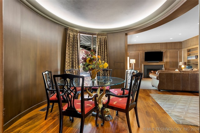 dining room with light hardwood / wood-style floors and wood walls