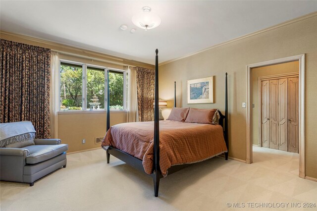 bedroom with ornamental molding and light colored carpet