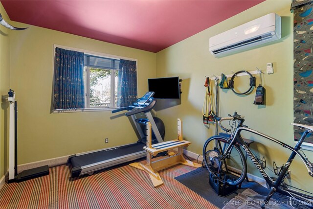 exercise area featuring a wall unit AC and carpet floors