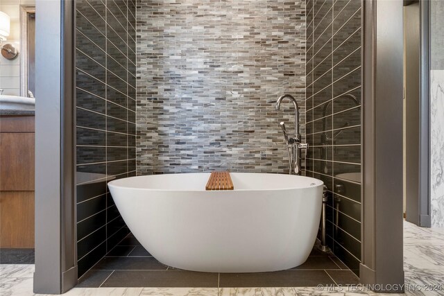 bathroom with tile walls and a tub