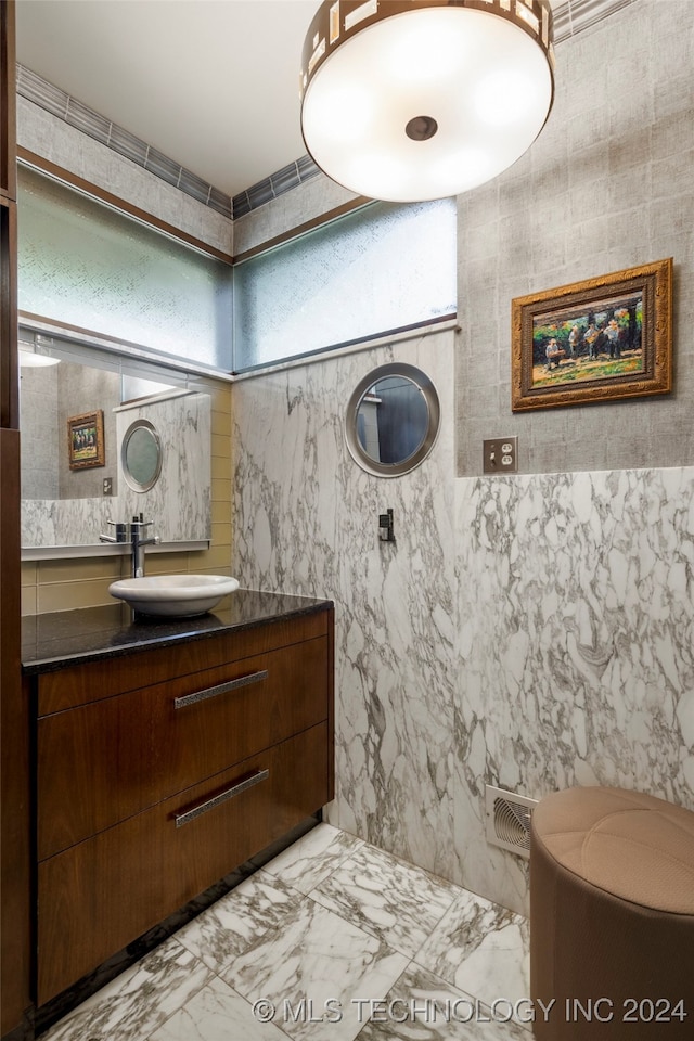 bathroom with tile walls, vanity, and toilet