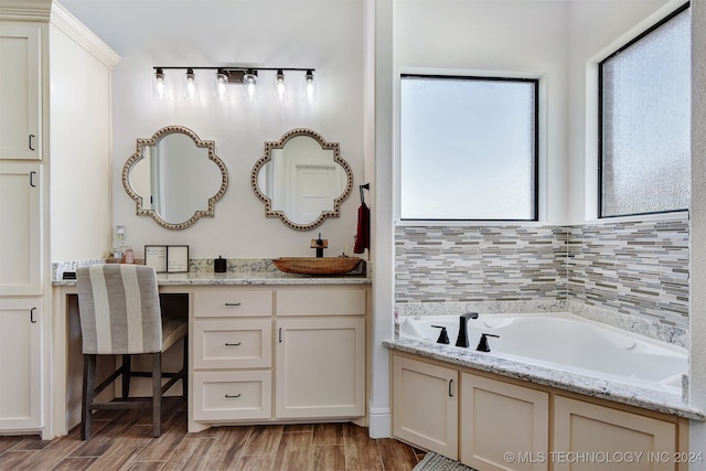 bathroom with vanity, a tub to relax in, and hardwood / wood-style flooring