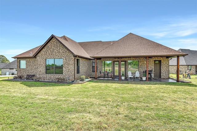 back of house with a yard and a patio