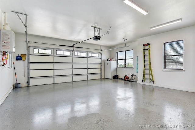 garage featuring a garage door opener, tankless water heater, and white fridge