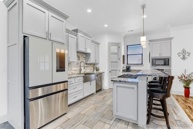 kitchen with pendant lighting, light stone countertops, stainless steel appliances, and sink