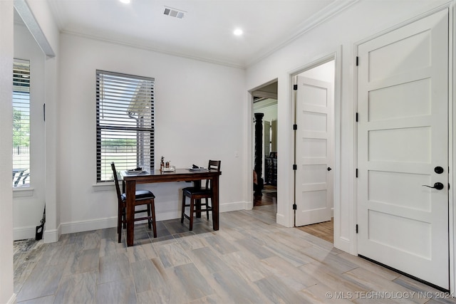 dining area with light hardwood / wood-style flooring and ornamental molding