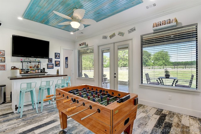 recreation room with ornamental molding, indoor bar, ceiling fan, and light hardwood / wood-style flooring