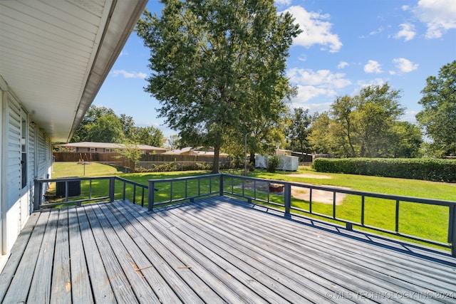 wooden deck featuring a lawn and a storage shed