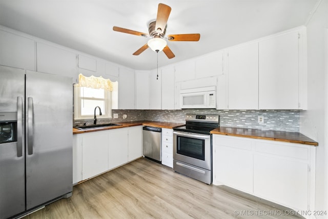 kitchen featuring light hardwood / wood-style flooring, appliances with stainless steel finishes, sink, ceiling fan, and white cabinets