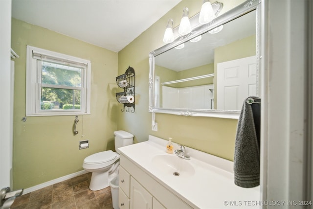 bathroom featuring vanity, toilet, and a shower