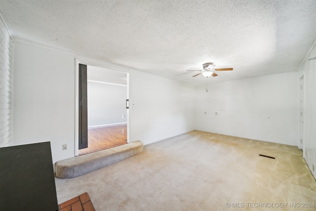 empty room featuring a textured ceiling, ceiling fan, and carpet floors