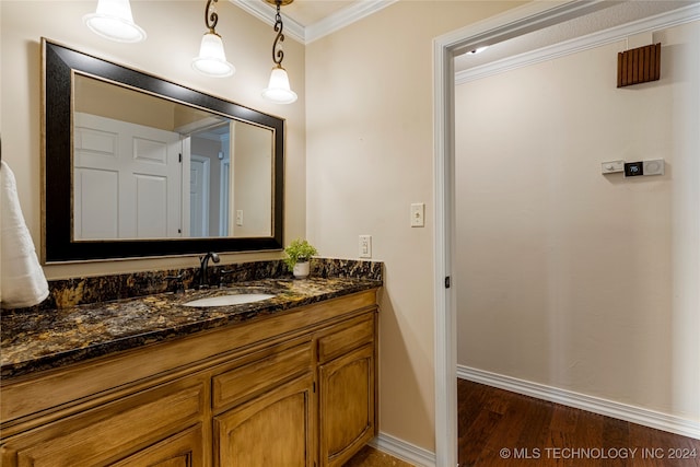 bathroom featuring wood-type flooring, vanity, and ornamental molding